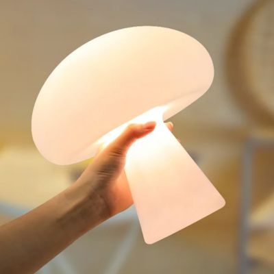 Lampe champignon blanche Cocon Blanc allumée dans une main féminine