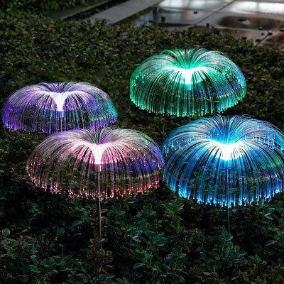 Lampe solaire extérieur méduse fibre optique multicolore vert violet bleu et rose plantées dans jardin la nuit, éclairage décoratif extérieur