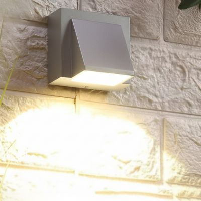 Luminaire extérieur gris sur mur extérieur en pierre