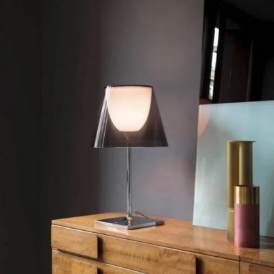 lampe de table LED allumée design italien postmoderne métal chrome et verre gris fumé sur commode bois clair mur de couleur gris bleuté