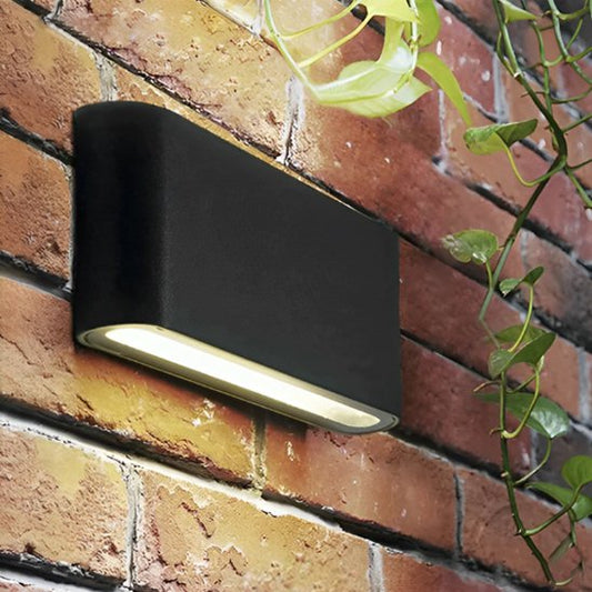 Applique exterieur murale LED noire gros plan sur mur briques rouges humide avec plante grimpante, éclairage directionnel bas design moderne
