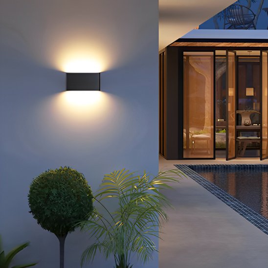 Applique exterieur murale LED Séléné noire double faisceau sur mur bleu terrasse villa luxe avec piscine plantes tropicales, éclairage architectural 