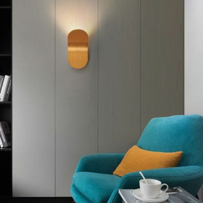 Applique murale dorée forme courbe dans petit salon fauteuil turquoise coussin jaune or