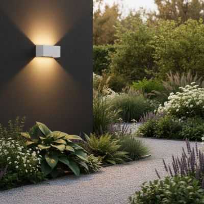 Applique murale extérieur rectangulaire blanc LED lumière bidirectionnelle illuminant mur gris charbon et plantes
