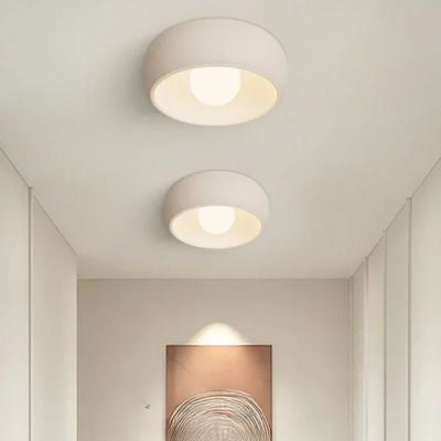 Deux plafonniers ronds designs blancs dans couloir blanc cadre au fond minimaliste