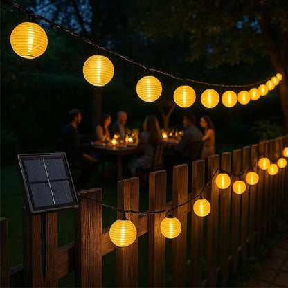 Guirlande solaire LED lanternes rondes dorées avec panneau solaire sur clôture bois jardin nuit, dîner 
convivial 