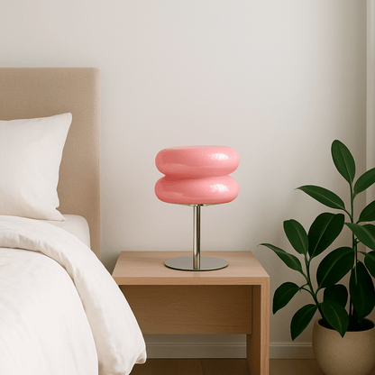 Lampe champignon type macaron en verre rose et chrome USB sur table de nuit bois clair un lit draps blancs tête de lit beige à droite plante verte pot blanc