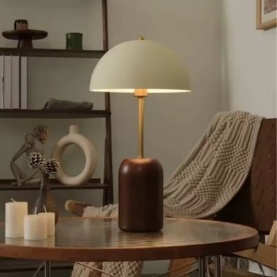 Lampe champignon allumée bois et fer sur table ronde chandelles blanches chaise cuire marron jeté beige ambiance chaleureuse nordique