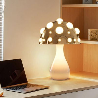 lampe champignon blanche à pois blanc allumée sur bureau avec ordinateur
