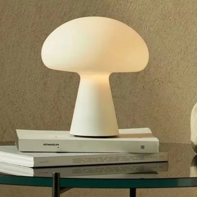 lampe champignon blanche sur livres table ronde en verre