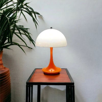 lampe champignon pied orage abat-jour blanc sur table bois et métal noir des fleurs séchées à gauche
