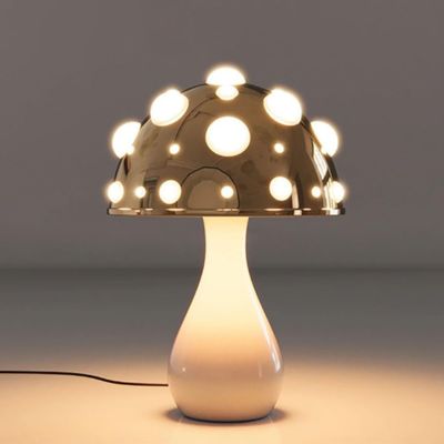 lampe champignon blanche à pois blanc allumée sur table blanche