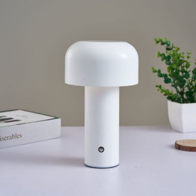 lampe champignon blanche sur table blanche un livre et petite plante dans pot blanc