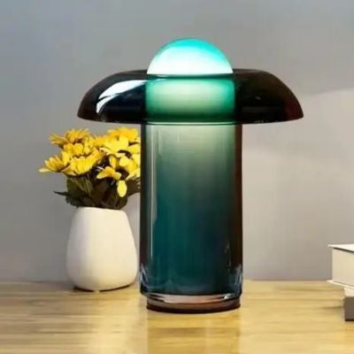 lampe champignon design verre vert allumée sur table fleurs jaunes pot blanc