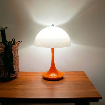 lampe champignon blanche et orange sur table en bois allumée un panier en rotin sur table