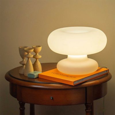 lampe champignon blanche en verre sur un livre dans un décor classique
