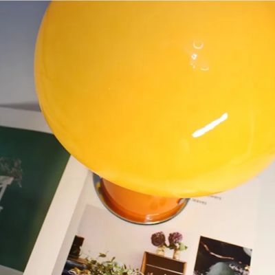 lampe champignon style Bauhaus orange en verre posée sur livre de décoration