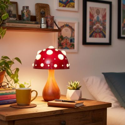 lampe champignon couleur bois rouge à pois blancs allumée sur bureau chambre plantes livres cadres