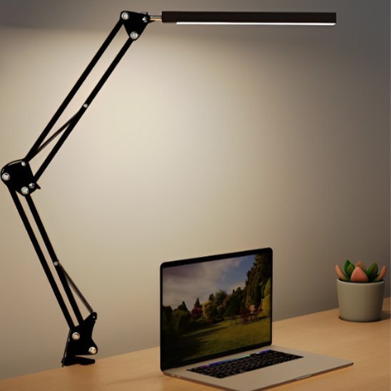lampe de bureau à clip noire allumée installée sur une table de travail un ordinateur portable est magnifiquement illuminé  