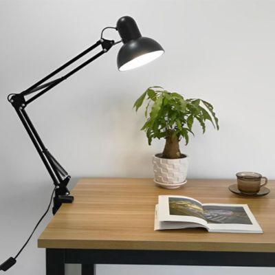 lampe de bureau LED de couleur noir fixée à une table une jolie plante verte un livre et une tasse de thé dans un style minimaliste