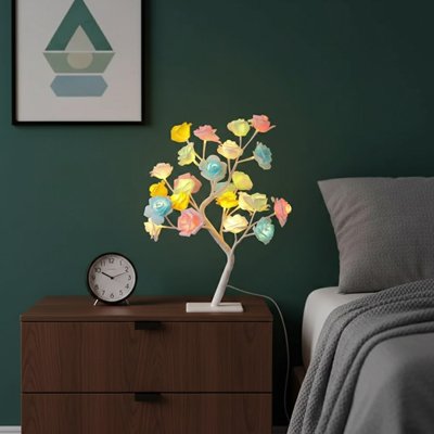 Lampe de chevet design forme arbre roses jaunes rose bleues allumées pied blanc sur table de nuit en bois style nordique