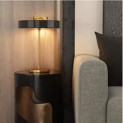 lampe de chevet noire et dorée style art deco sur table noire