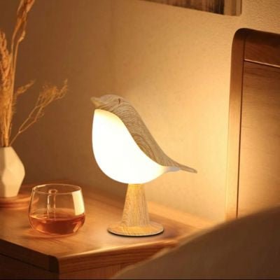 lampe de chevet tactile oiseau allumée sur table de chevet verre et vase fleurs séchées