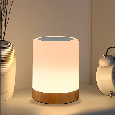 Lampe de chevet tactile allumée sur table de nuit blanche réveil matin vase beige