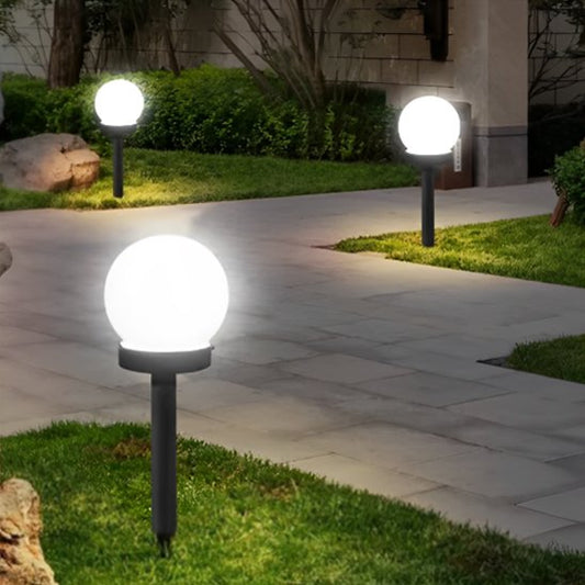 Lampe de jardin installée le long d'une allée de jardin au crépuscule
