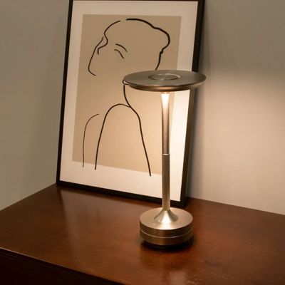 lampe de table design argent sur commode en bois un dessin minimaliste encadrée d'une femme