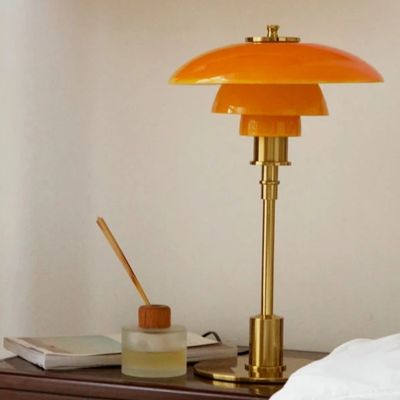 lampe de table pied cuivre abat-jour orange sur table de chevet