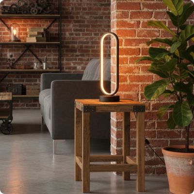 lampe de table minimaliste sur table bois salon bohème industriel étagère fer noir et tablette bois murs en briques canapé gris grosse plante verte en premier plan