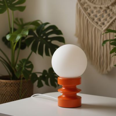 lampe de table rouge orangé éteinte en bois et verre dépoli LED sur table blanche dans une ambiance bohème