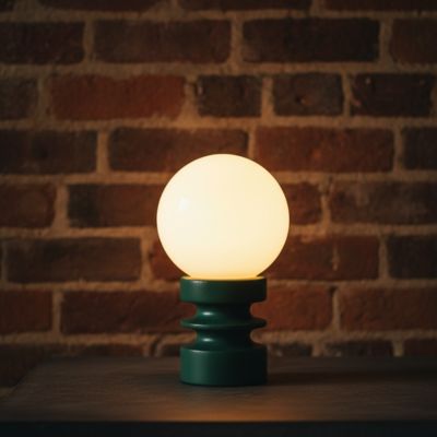lampe de table vert forêt allumée LED sur table noire mur brique look industrielle