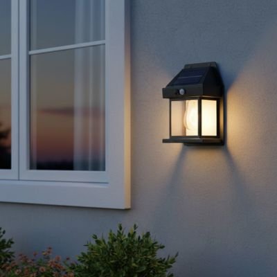 Lampe extérieur détecteur de mouvement noire style lanterne sur mur blanc façade maison au crépuscule 