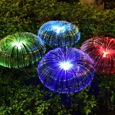 Lampe solaire extérieur méduse fibre optique multicolore vert violet bleu plantées dans jardin la nuit, éclairage décoratif extérieur