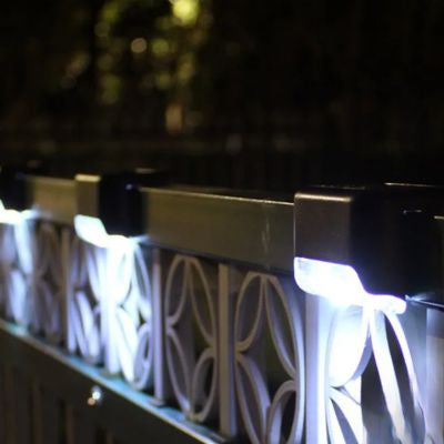 Lampe solaire noire extérieur lumière blanche trois sont installées sur barrière métal blanc