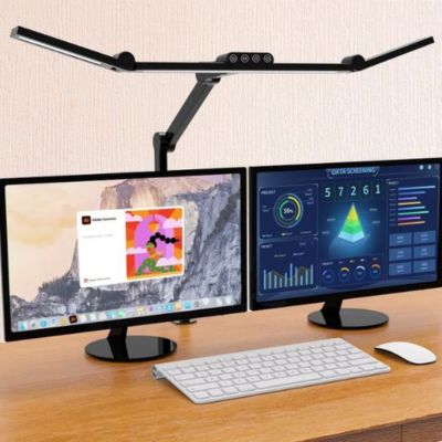 Lampes de bureau moniteur noire éclairant double écran sur bureau bois avec clavier blanc souris et graphiques analytics affiches