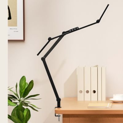 lampes de bureau moniteur noire avec angle rotation 45 degrés sur bureau bois avec clavier documents horloge bleue plante et tableau paysage