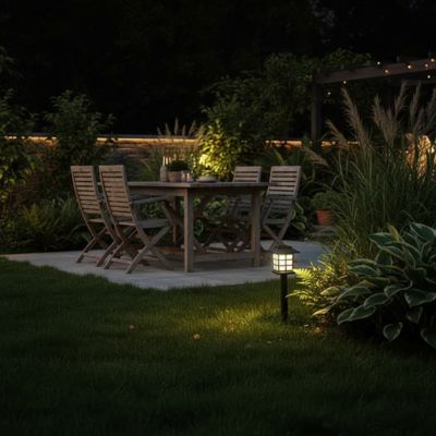 Lanterne extérieur style pagode  japonnaise lumière chaude plantées dans herbe près table chaises bois ambiance soirée jardin cosy