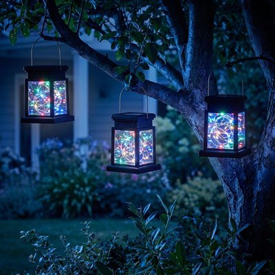 Lanterne solaire extérieur décorative LED suspendue à branches d'arbre dans jardin nocturne, lumière multicolore ambiance féerique