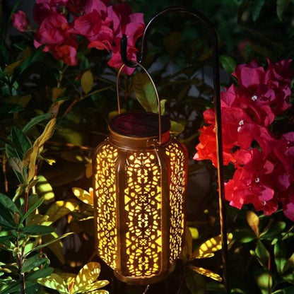 Lumière solaire extérieur LED cuivre ajourée dans massif fleuri roses et bougainvilliers, lumière chaude décorative jardin nocturne