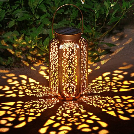 Lumière solaire extérieur cuivre ajourée projetant motifs lumineux dorés sur terrasse jardin, éclairage décoratif ambiance chaleur