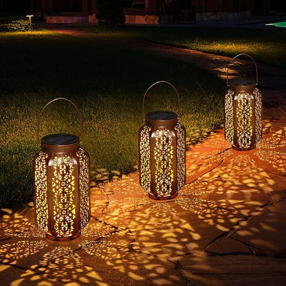 Lumière solaire extérieur LED cuivre ajourée trois sont alignées sur allée jardin nocturne projetant motifs lumineux dorés décoratifs