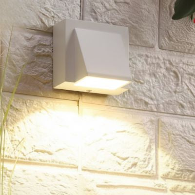 Luminaire extérieur blanc sur mur extérieur en pierre  