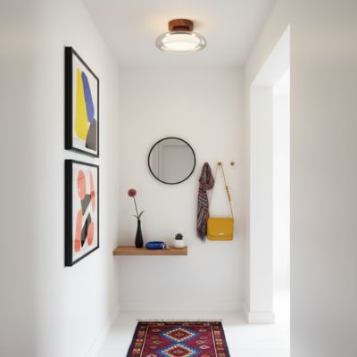 Plafonnier en verre transparent design postmoderne dans petite entrée artistique blanche objets colorés éclectique