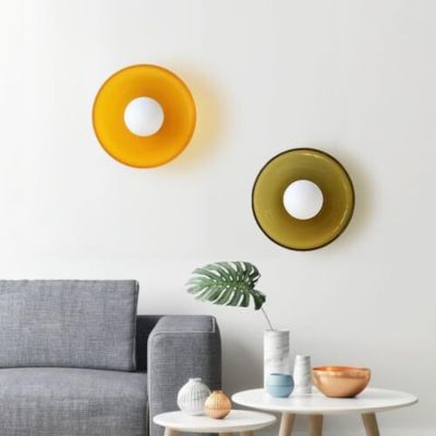 Deux plafonniers un vert olive un orange en verre vintage installés comme applique murale dans salon nordique