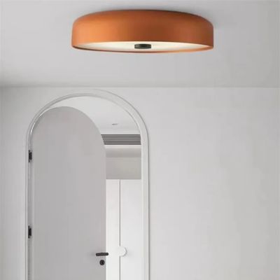 Plafonnier couleur terracotta minimaliste design italien dans pièce blanche porte en arc
