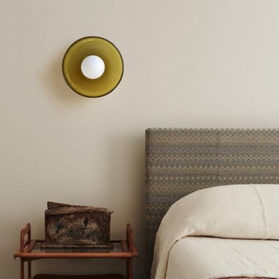 Plafonnier vert olive en verre vintage installé comme applique murale dans chambre nordique contemporaine